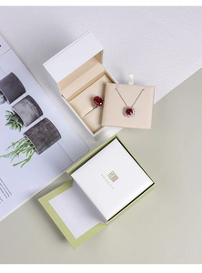 Detail of premium green silk jewelry gift box featuring elegant ribbon and gold logo