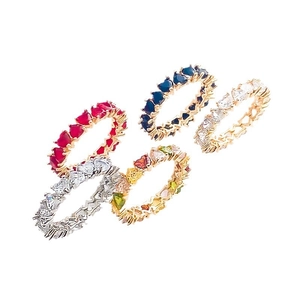 Detailed view of stacked heart-cut eternity rings with colorful zircon and gold plating