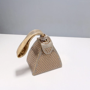 Detailed macro view of a gold triangular evening bag featuring sparkling rhinestones