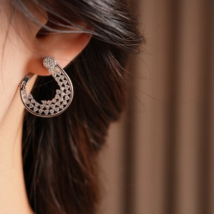 Close-up of silver pave-set hoop earrings with sparkling cubic zirconia on a model ear