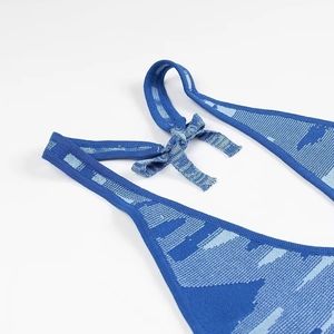 Détail de robe en maille bleue montrant les bretelles nouées et le motif jacquard