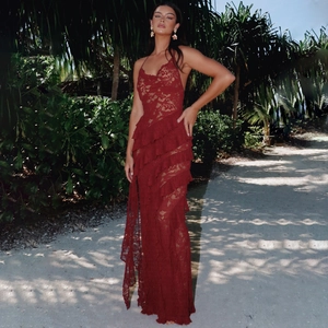 Close-up of deep red lace fabric with tiered ruffle details and sheer crochet texture