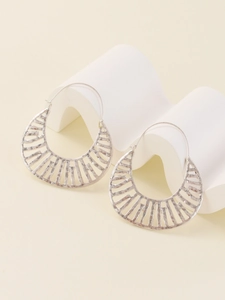 Detailed close-up of silver hollowed-out hoop earrings with striped geometric lattice design