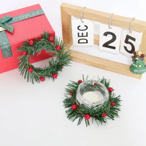 Close-up of artificial holly berry candle ring with pine needles and red gift boxes