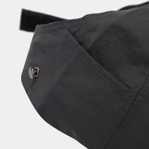 Detail shot of black sports cap featuring premium double-line stitching and metal rivet