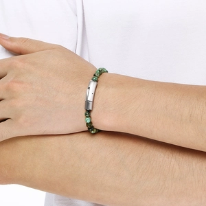 Detail of beaded bracelet featuring green stones and brushed titanium steel buckle