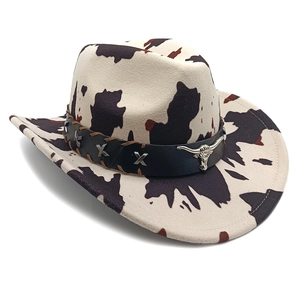 Detail of cow print cowboy hat with black leather band and silver bull head emblem