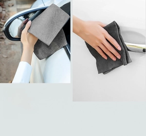 Microfiber magic cleaning cloth wiping a car rearview mirror and door handle effectively