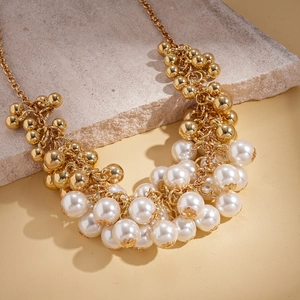 Detail of baroque pearl sweater chain with gold beads and layered cluster design