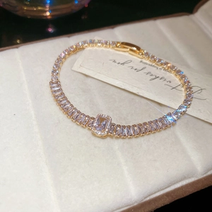 Detailed close-up of 18K gold plated flower bracelet with baguette cubic zirconia stones