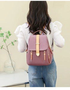 Purple nylon backpack for women with yellow straps and gold zippers on a model