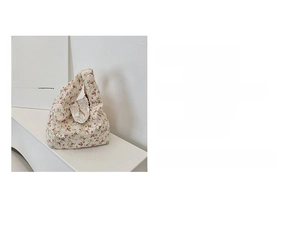 Detail of floral canvas handbag showing polyester fabric texture and button closure