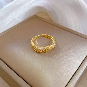 Close-up of gold-plated twisted ring featuring micro-pave cubic zirconia on silk cloth