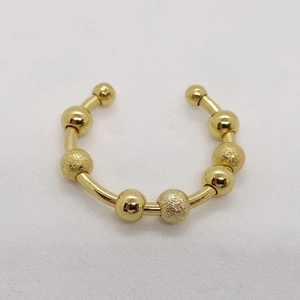 Detailed macro view of golden stainless steel ring with polished and frosted beads