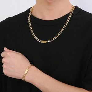 Modèle masculin portant un ensemble de collier et bracelet gourmette en acier doré