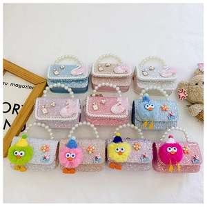 Flat lay of colorful sequin children handbags with pearl handles and cartoon patches
