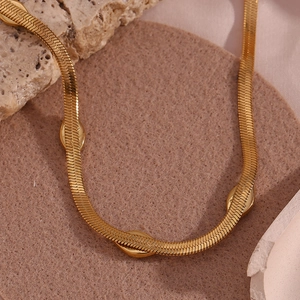 Macro shot of 18K gold plated snake chain necklace with polished oval bead accents