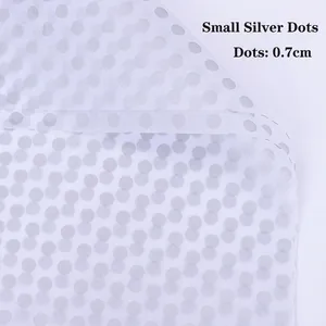 Close-up of semi-transparent white floral wrapping paper with 0.7cm silver polka dots