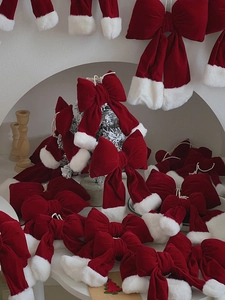 Close-up of red velvet Christmas bows with white plush edges in a festive scene