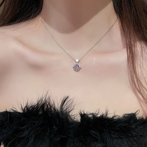 Detail of 14k gold plated rose pendant necklace with zircons worn on female neck