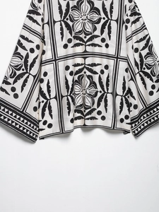 Détail rapproché de l'imprimé géométrique floral noir et blanc sur tissu fluide