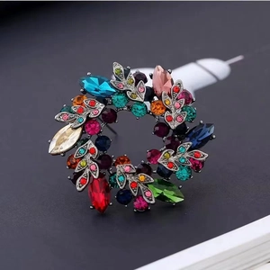 Detail of vintage wreath brooch with multi-colored crystals and black gunmetal base