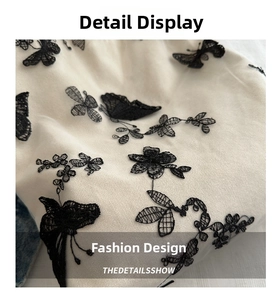 Macro detail showing vintage black butterfly embroidery on beige canvas bucket bag