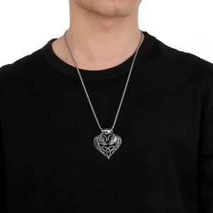 Detail of Viking double wolf heart pendant on round box chain worn by male model