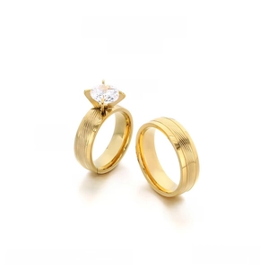 Detail of gold-plated stainless steel couple rings with rhinestone and brushed finish