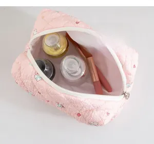 Detail showing pink quilted cosmetic bag with cat and heart prints for travel storage