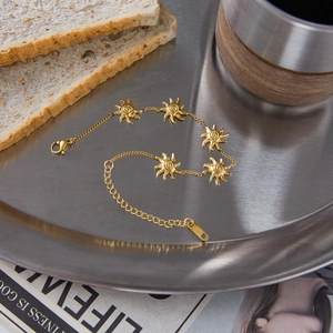 Dettaglio del bracciale sole in acciaio inossidabile placcato oro 18K su vassoio