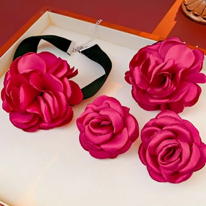 Detail view of deep rose velvet floral choker and matching accessories in a display box