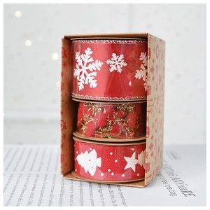 Close-up of three rolls of red Christmas ribbons with gold glitter and snowflake patterns