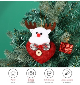 Hanging heart Christmas ornament with plush reindeer and wooden button on a festive tree