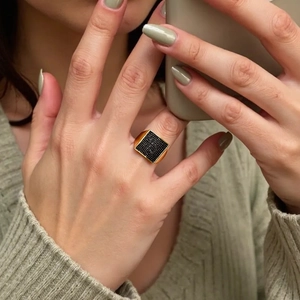 Detailed macro view of an 18K gold plated square ring featuring black micro-pave setting