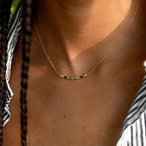Close-up of S925 silver necklace with colorful teardrop diamonds on a female neck