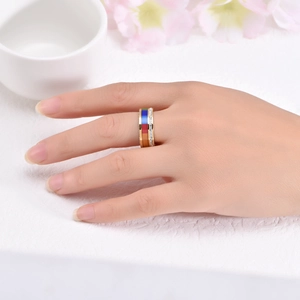 Detail of gold ring featuring colorful striped enamel and pavé zirconia on finger