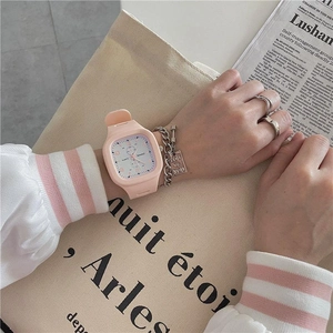 Pink square quartz watch for girls styled with a silver bracelet on a canvas bag