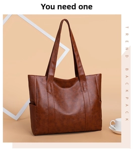 Detail of dark brown leather tote bag with lychee texture and sturdy vertical stitching