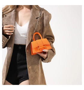 Detail of a mini orange beaded chain square bag in lychee pattern leather for women