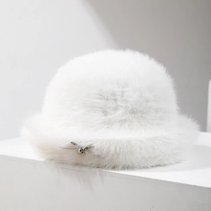 Close-up of white plush faux rabbit fur bucket hat with silver drawstring bow and bell