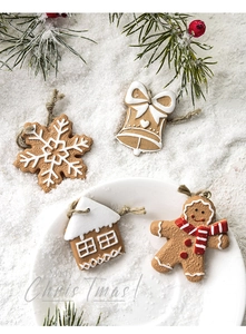 Detail of gingerbread man and snowflake resin ornaments with rustic hanging twine for Christmas