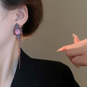 Detail of vintage flower tassel earring with purple crystals and pearl accents