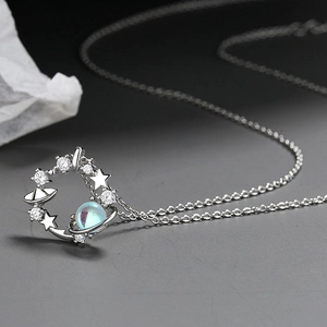 Macro shot of silver cosmic necklace pendant with zircon stones and iridescent moonstone