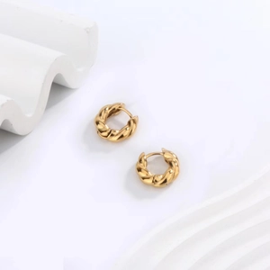 Detail of gold-plated stainless steel hoop earrings with twisted rope texture and high polish