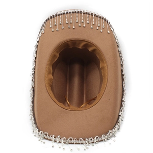 Dettaglio del cappello da cowboy kaki con frange di strass argentati brillanti e nappe