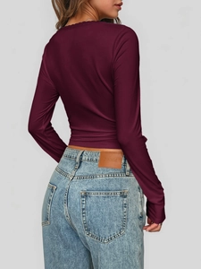 Rückansicht eines weinroten Langarm-Tops mit Cross-Saum und Jeans in blauer Waschung