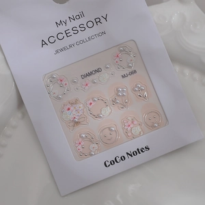 Close-up of 3D embossed nail art stickers with pink flowers, pearls and silver motifs