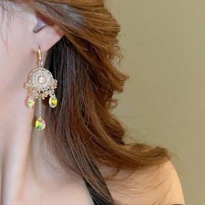 Detailed view of colorful drop crystal tassel earrings worn on a female model