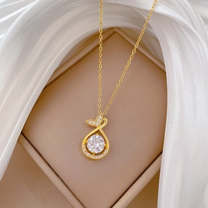 Macro shot of gold fishtail necklace with large crystal in elegant gift box